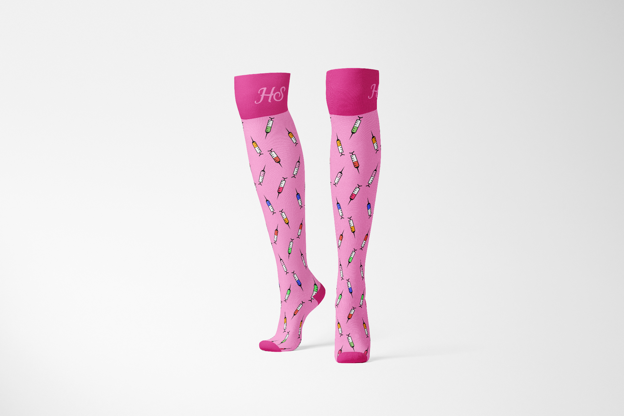 A pair of pink compression socks with colorful splashes and dots pattern, displayed against a white background.